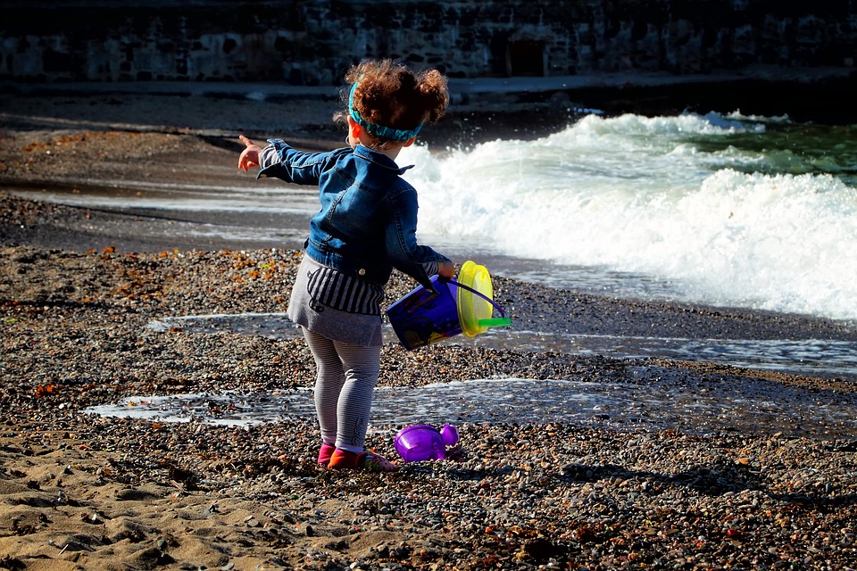 Toddlers exploring the world around them small girl by the sea