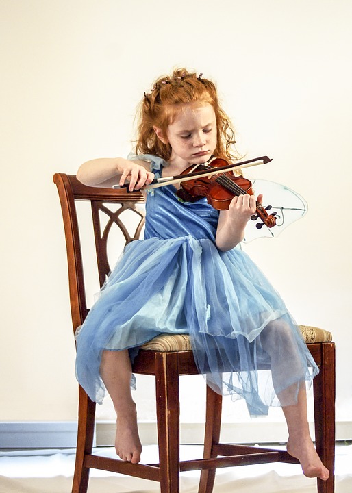 Child learning to play the violin Child learning to play the violin