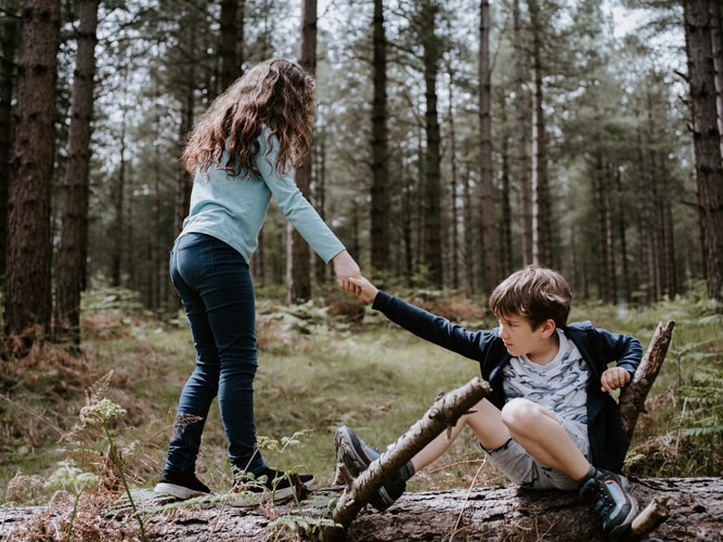 Girl helping a boy up Girl helping a boy up