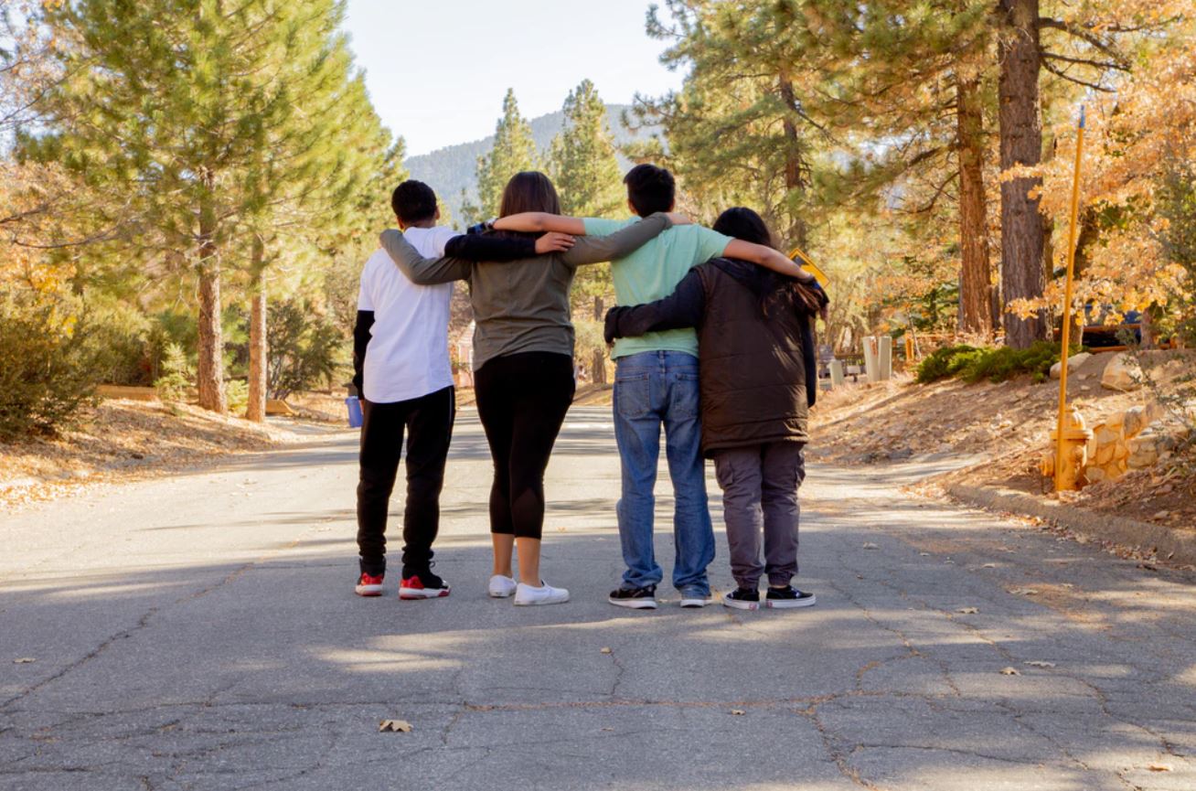 Friends with arms across each others shoulders Friends with arms across each others shoulders