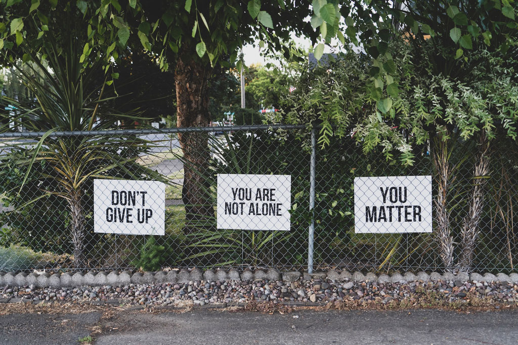 messages on a fence 'don't give up', ' you are not alone', 'you matter'