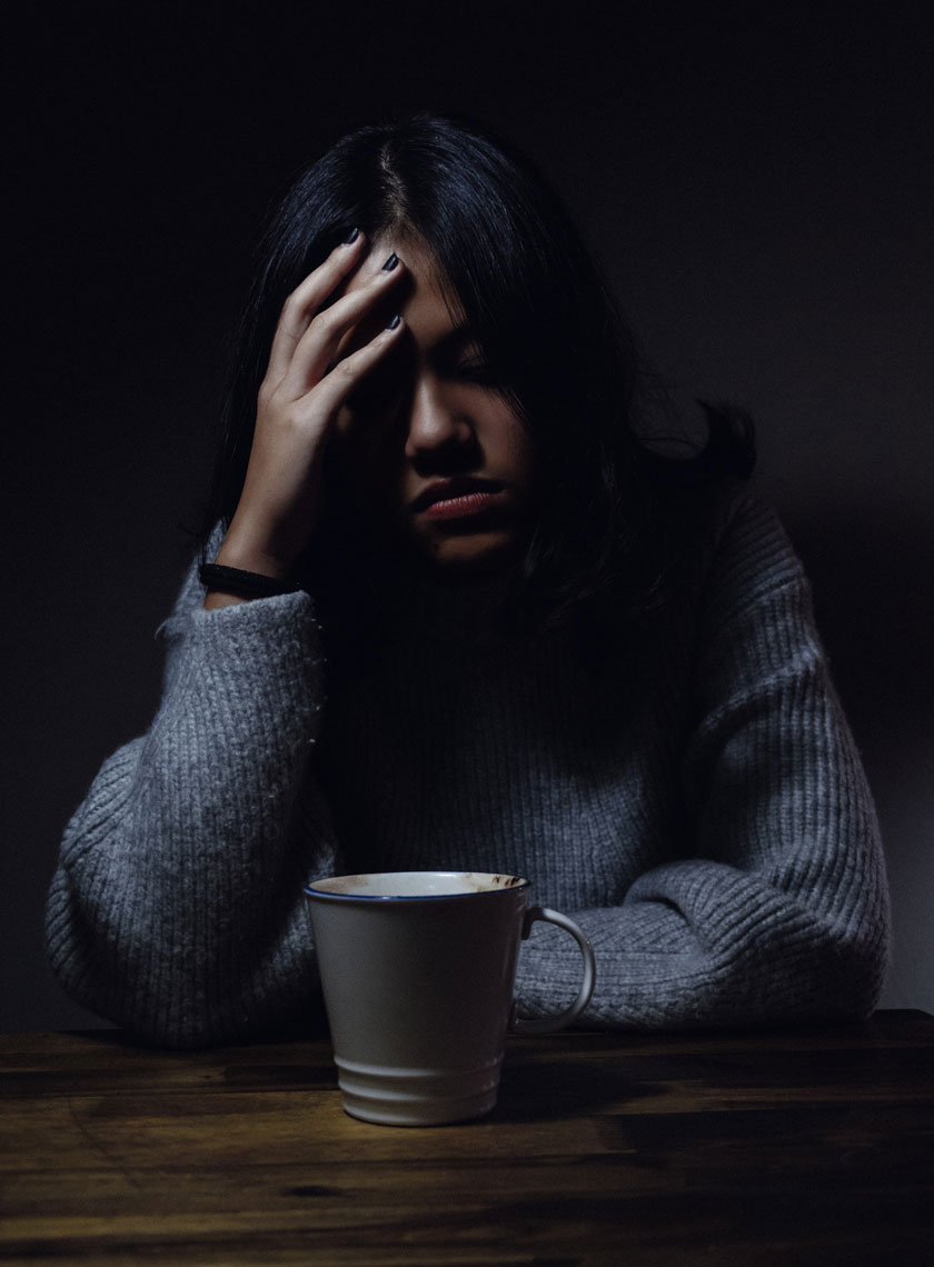 asian girl at table with a coffee mug