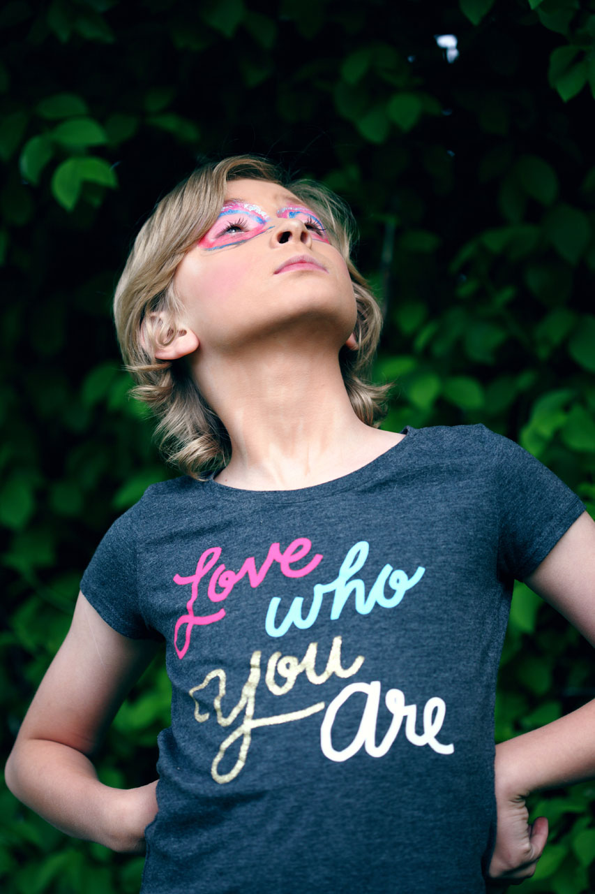 young person arms akimbo wearing a t-shirt with message love who you are